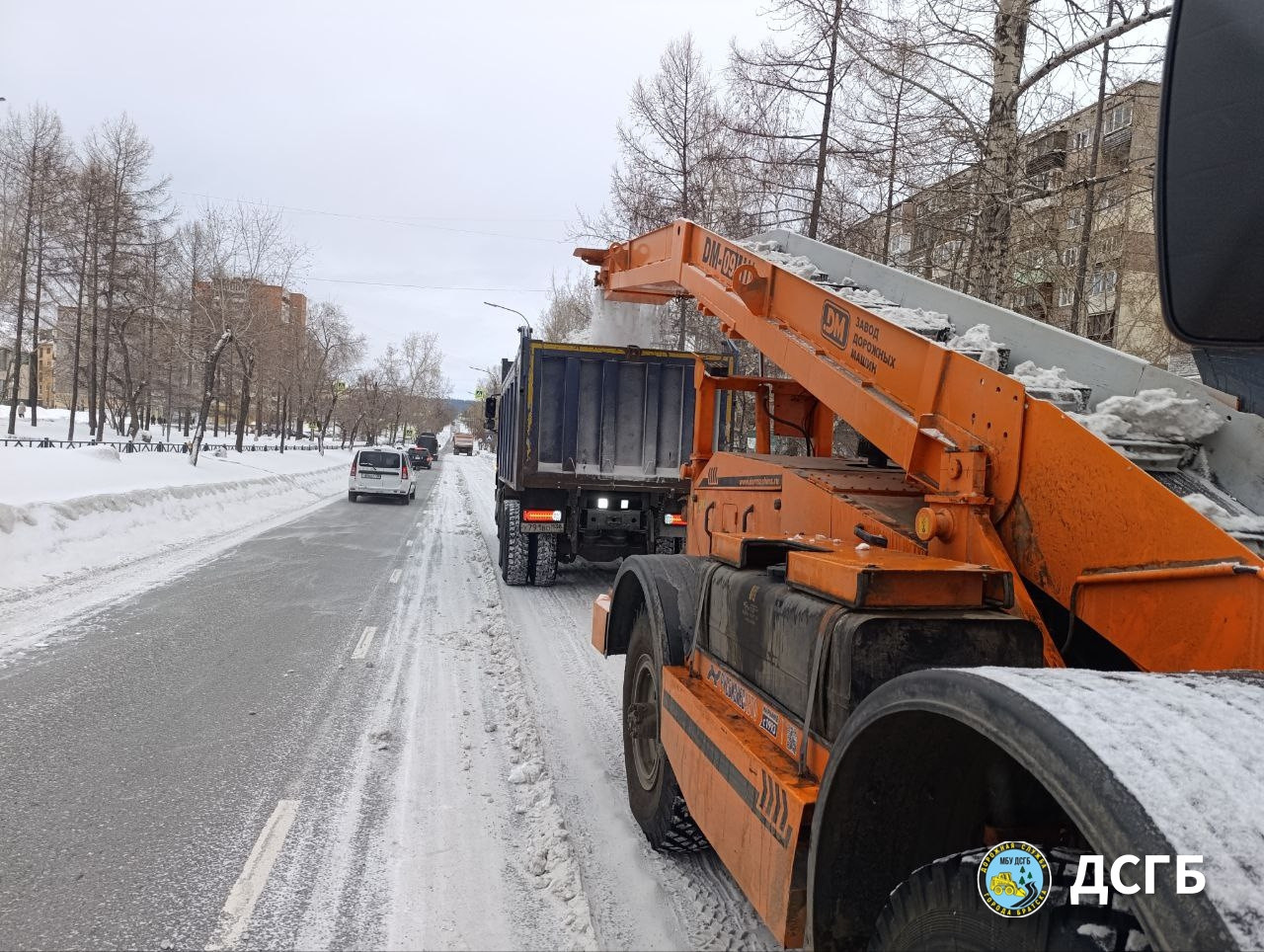 Очистка дорог от снега в зимнем городе.