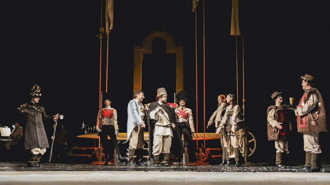 Театральная сцена с актерами в костюмах.