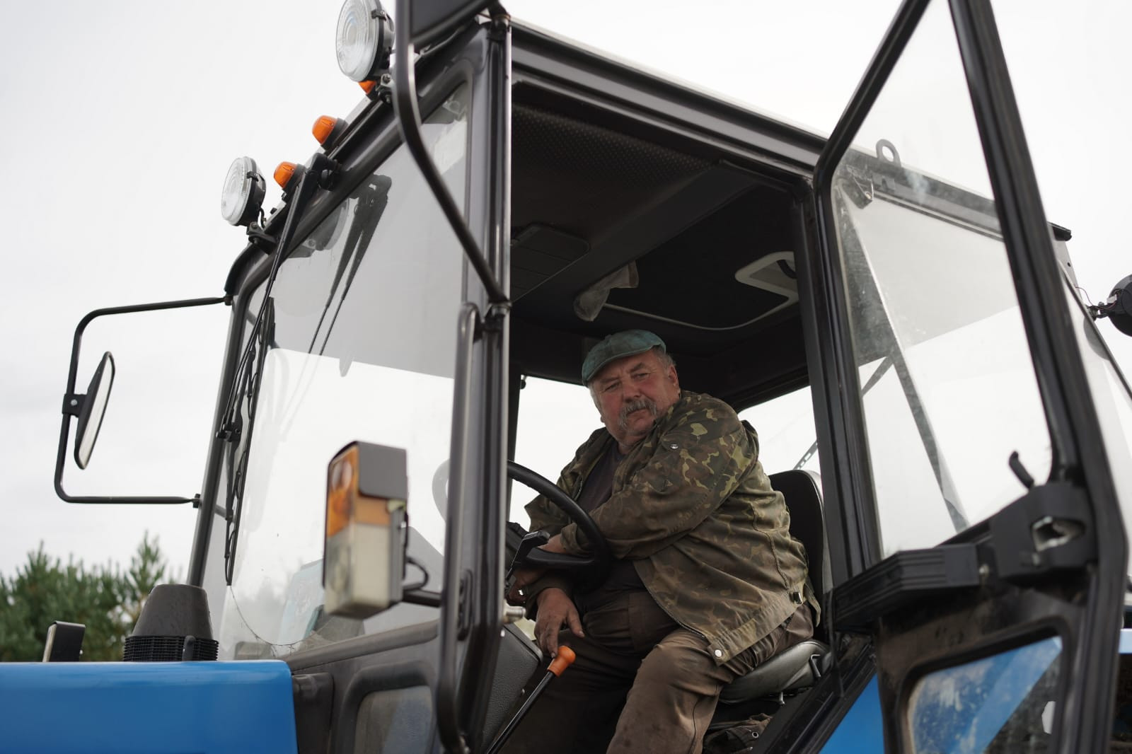 Мужчина в тракторе смотрит в окно.