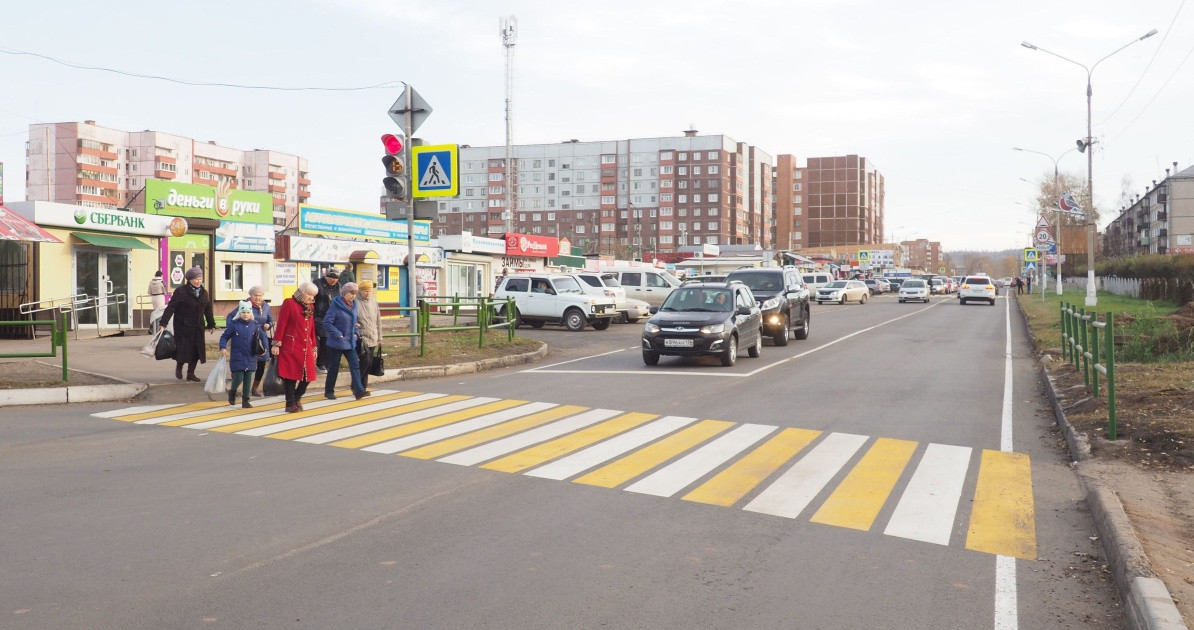 Пешеходы переходят дорогу по зебре в городе.