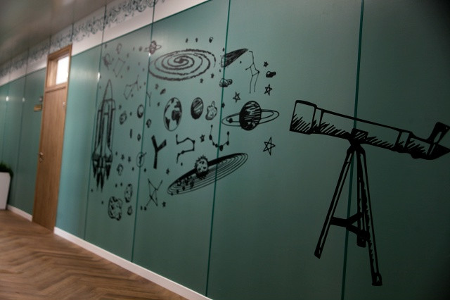 Настенная роспись с телескопом и космическими рисунками.