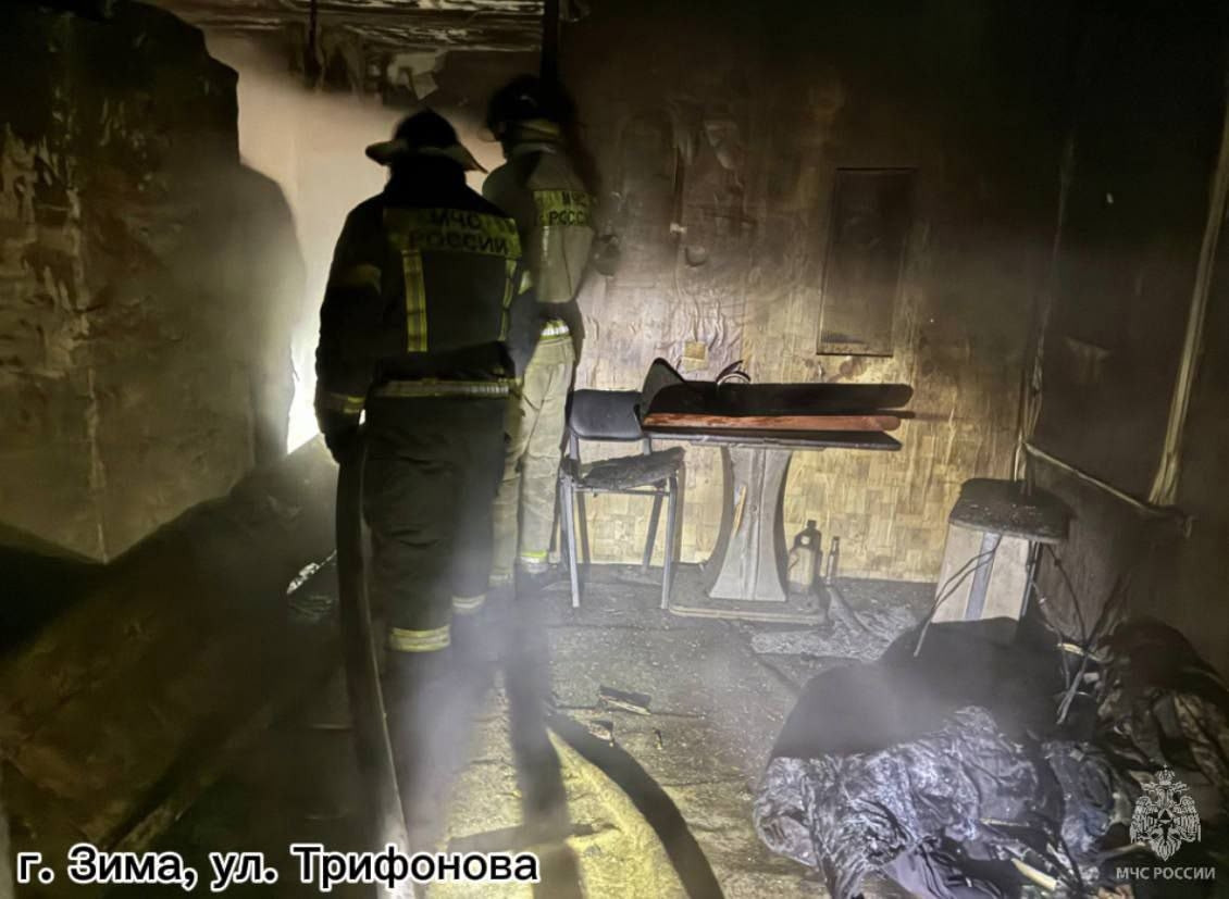 Пожарные работают в задымлённой комнате после пожара.