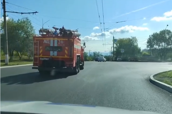 Пожарная машина на асфальтированной дороге, солнечный день.