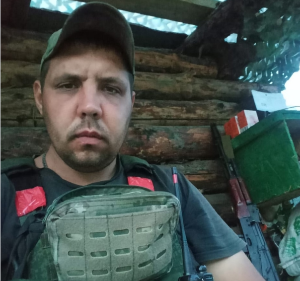 Мужчина в военной форме в укрытии с автоматом.