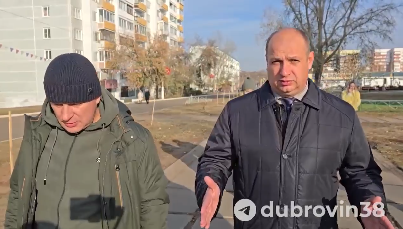 Двое мужчин идут по городской улице.