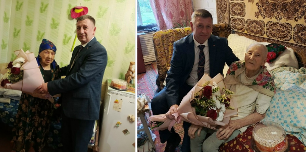 Мужчина вручает цветы пожилым женщинам дома.