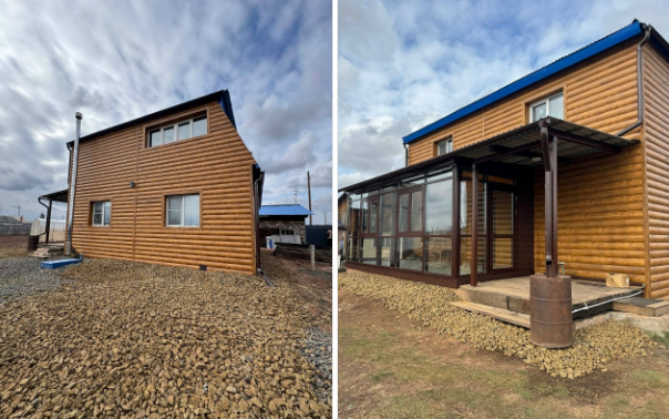 Деревянный дом с синим горбатым, облачным небом.