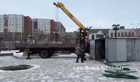 Строительные работы возле жилых домов и подъемного крана.