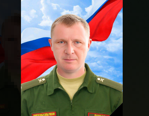 Мужчина в военной форме на фоне флага России.