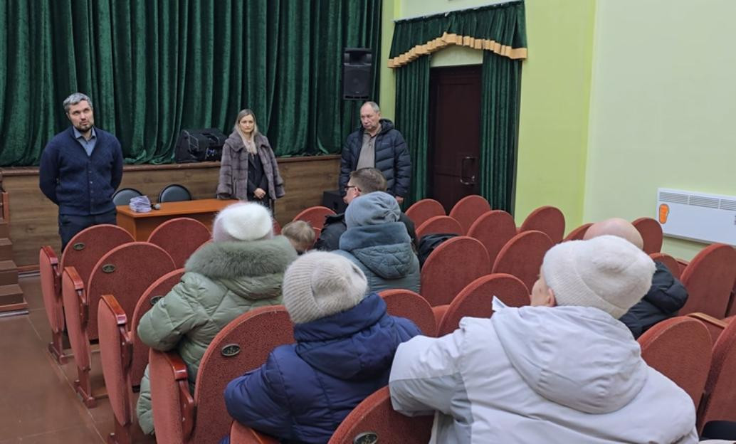 Люди сидят в зале на собрании.