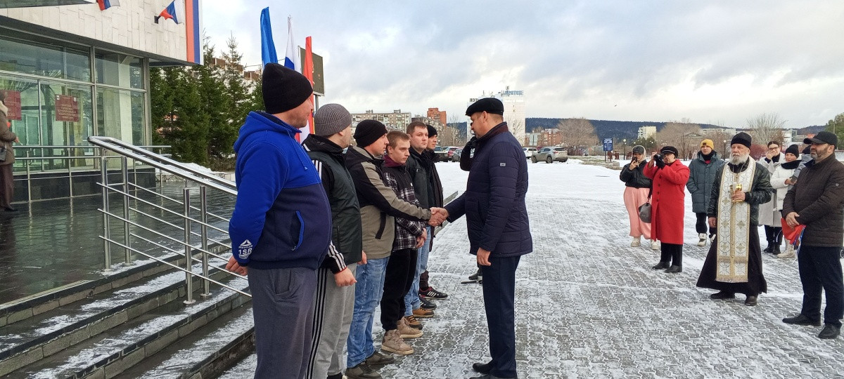 Мероприятие на улице, люди обмениваются рукопожатием.
