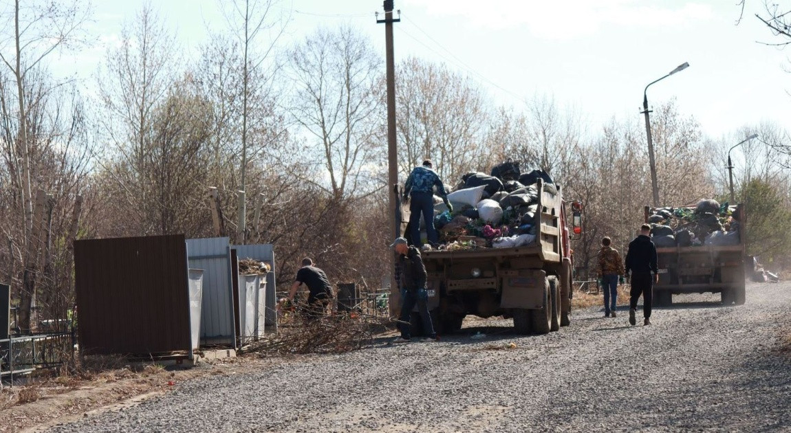 Грузовики собирают мусор на сельской дороге