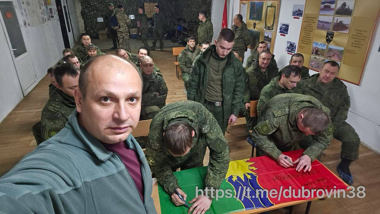 Военные подписывают флаг в комнате собраний.