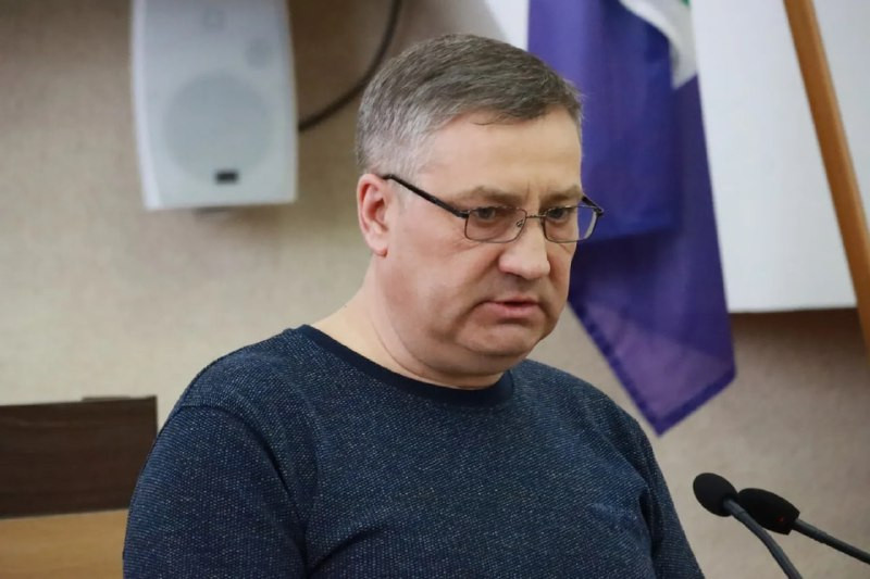 Человек выступает на конференции перед микрофоном.