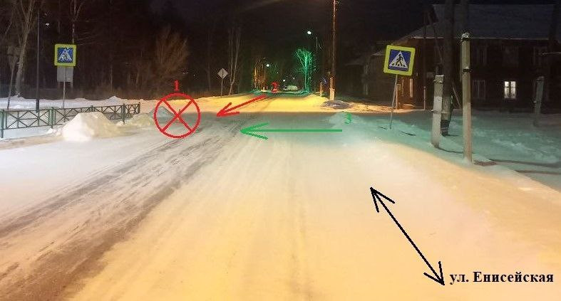 Заснеженная улица ночью с дорожными знаками.