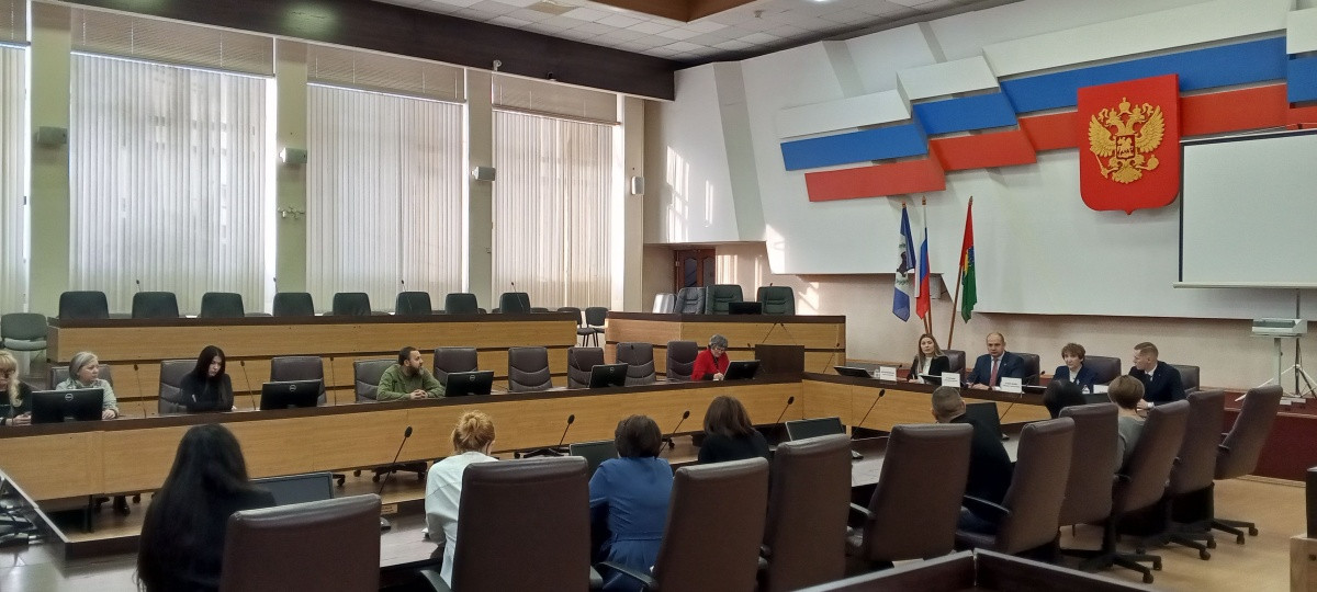 Совещание в конференц-зале с российским гербом.