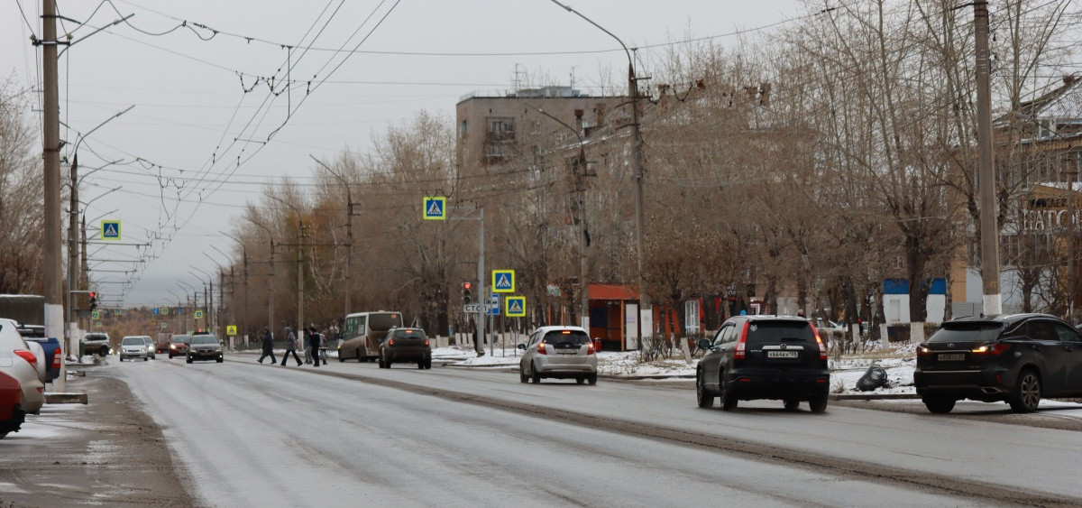 Улица с машинами и пешеходами в городе зимой.