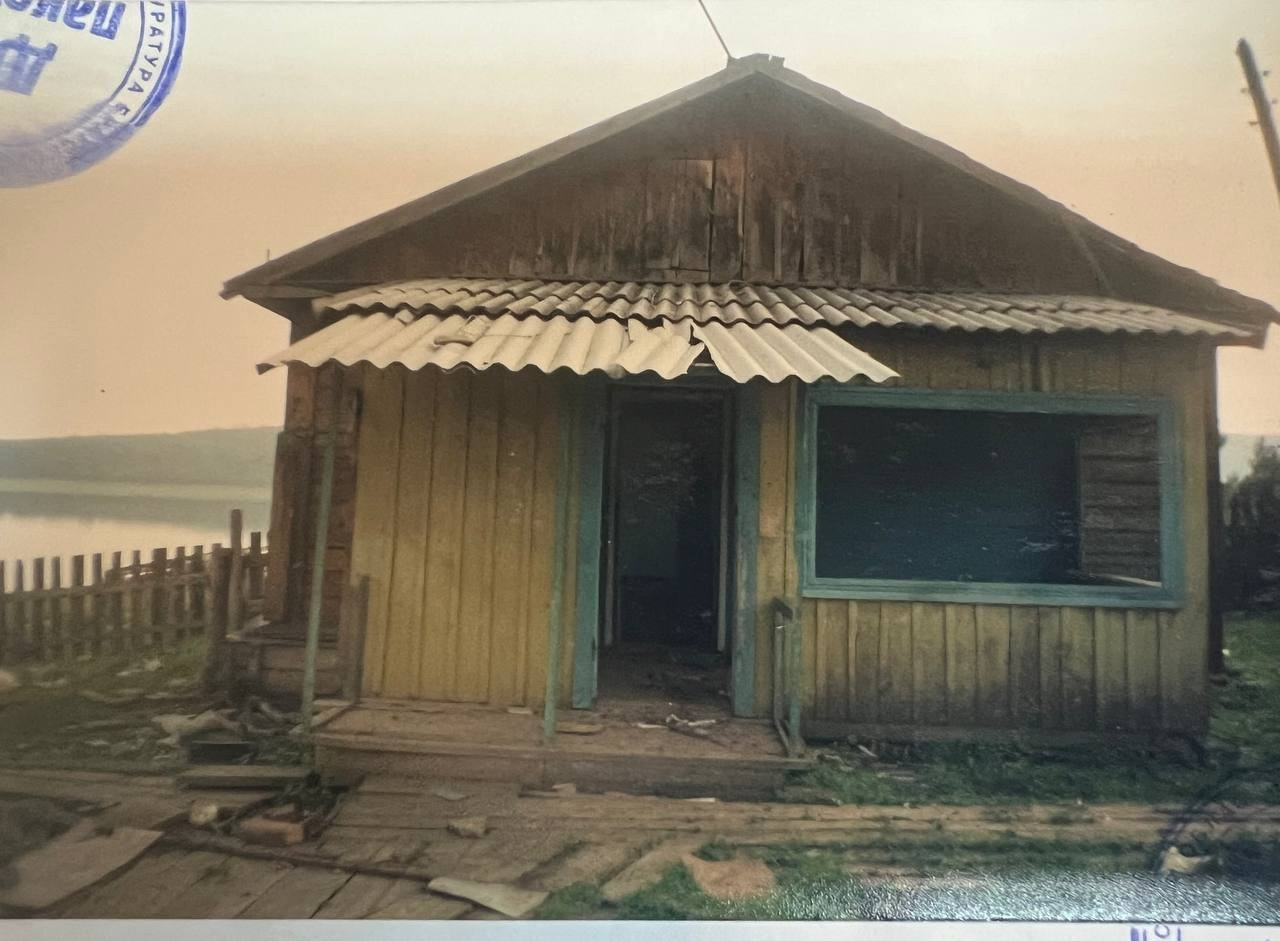 Старая деревянная хижина на берегу озера.