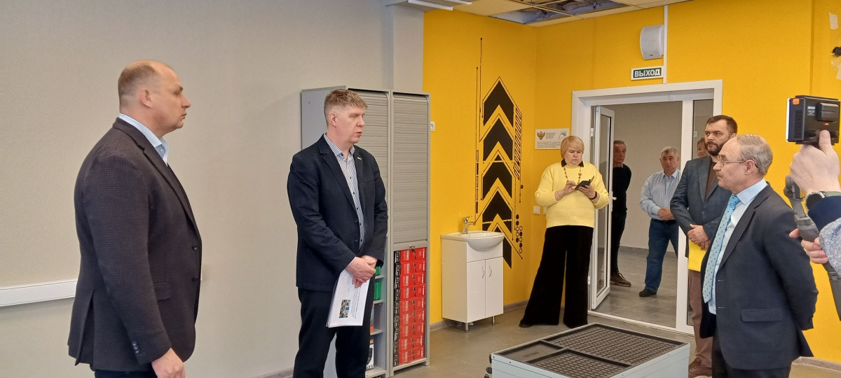 Люди общаются в офисном помещении возле выхода.