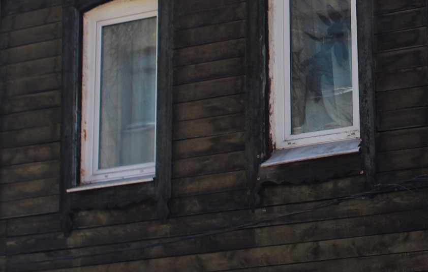 Два окна на деревянной стене здания