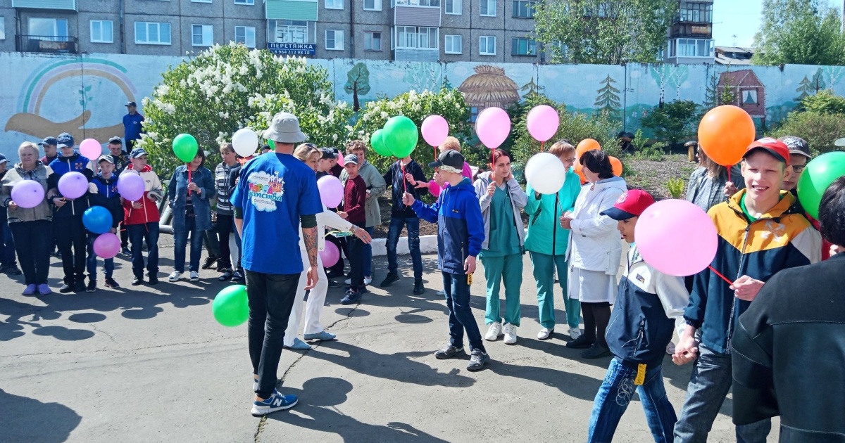 Люди на улице держат воздушные шары.