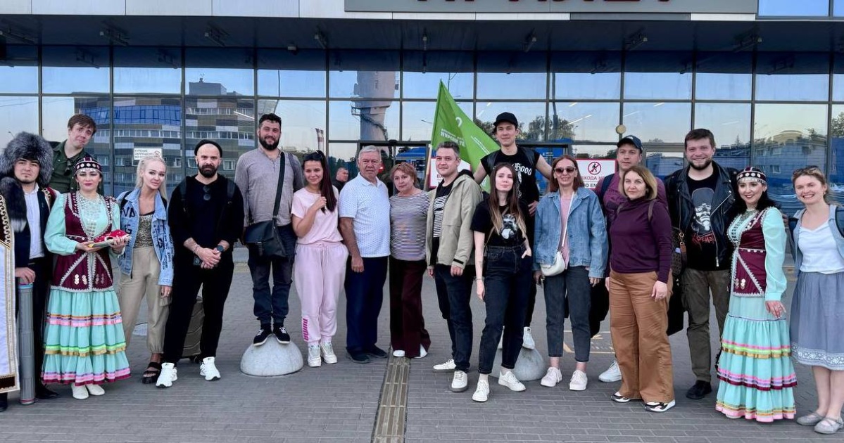 Группа людей возле здания аэропорта.