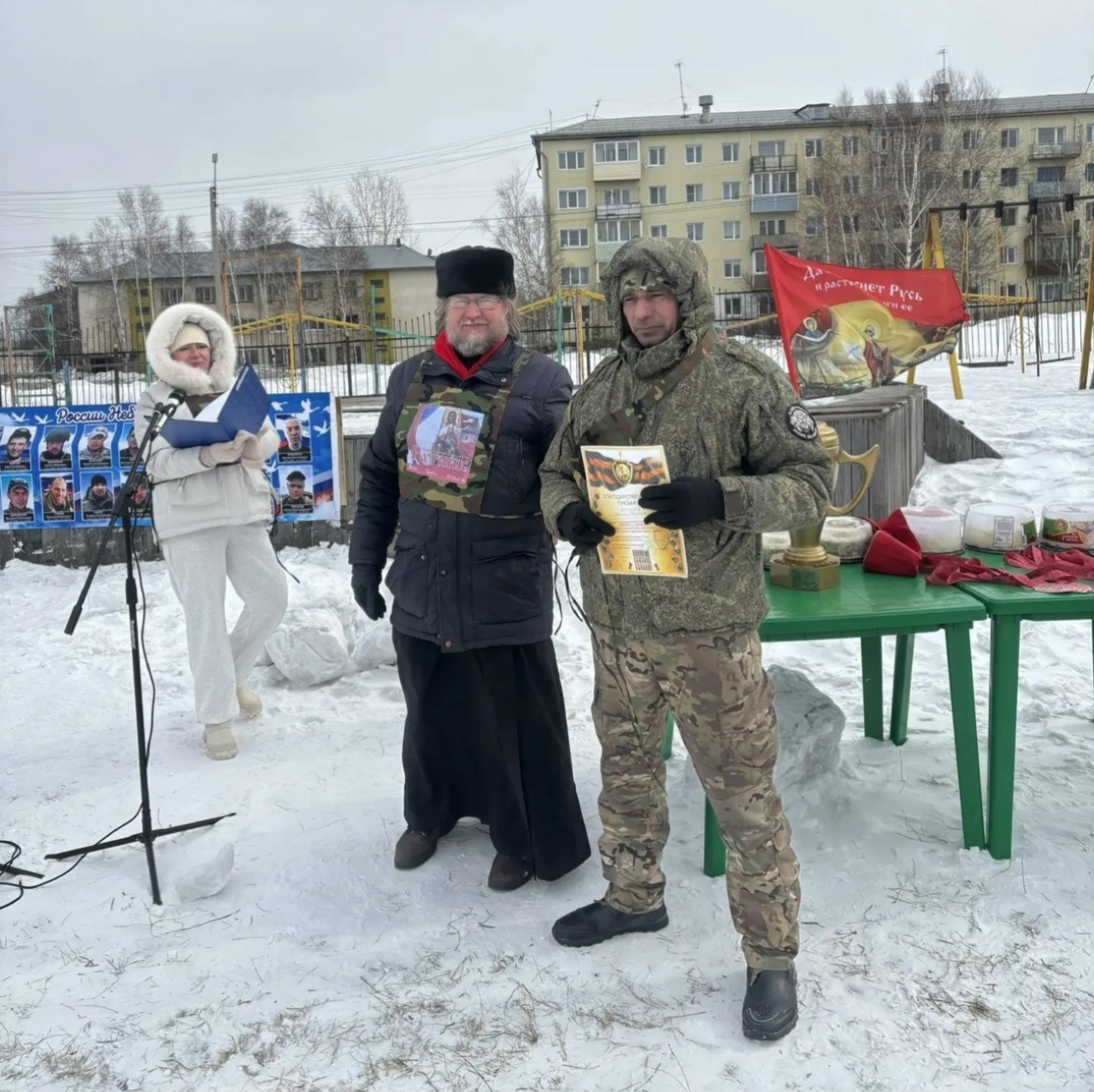 Трое людей на снежной улице с плакатами