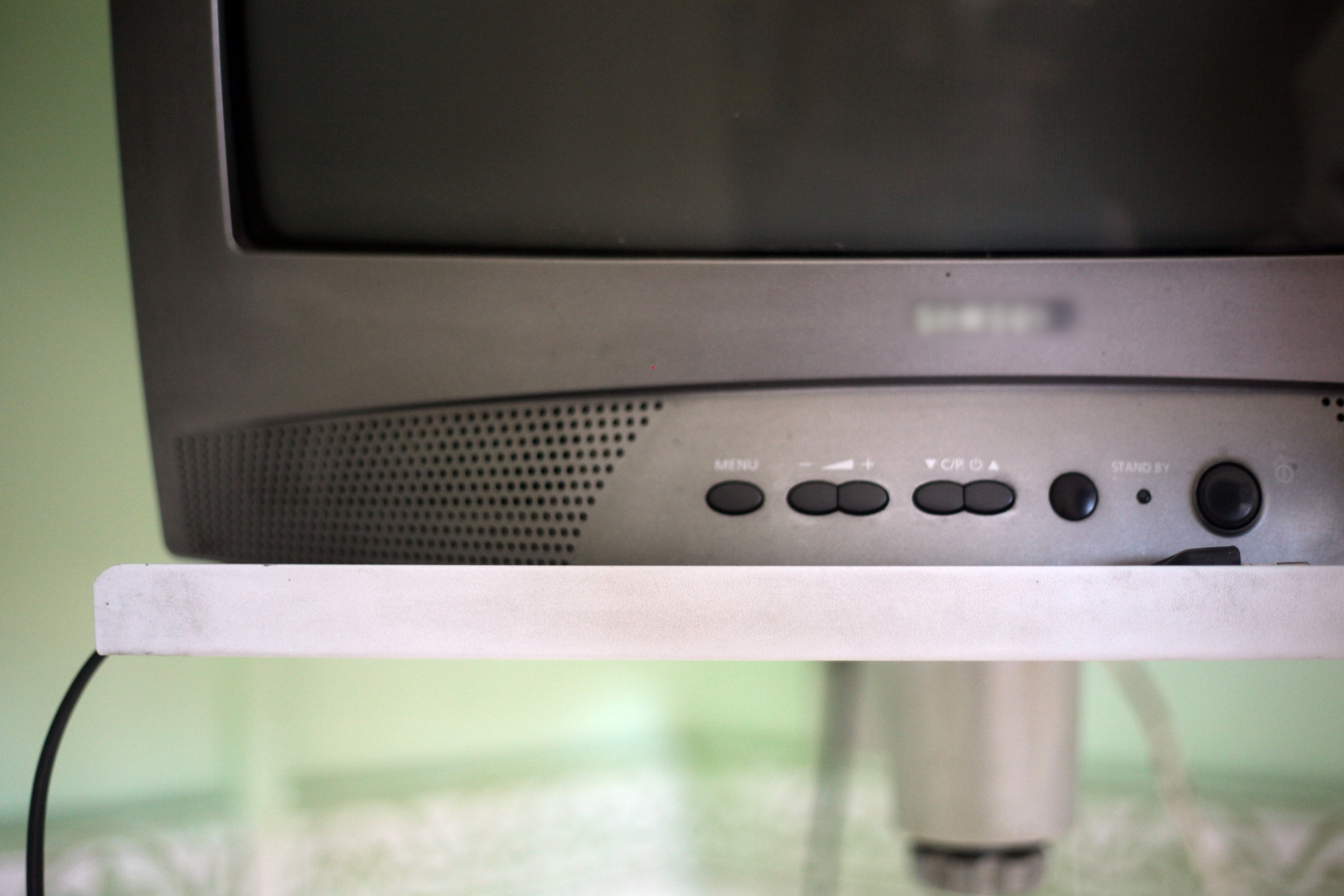 Старый телевизор с кнопками управления и экраном.