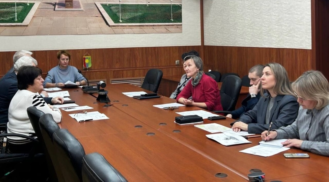 Люди на встрече за столом, обсуждение документов.