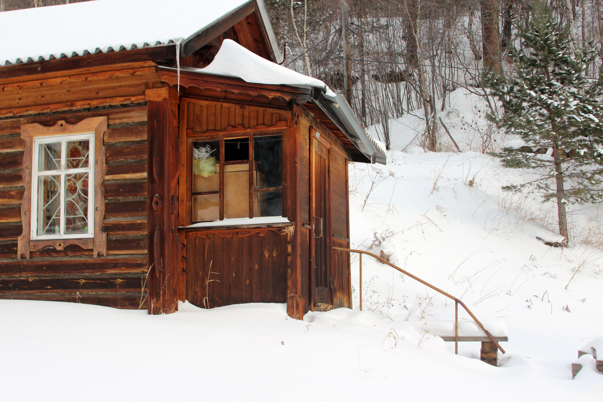 Старая деревянная изба в снегу.