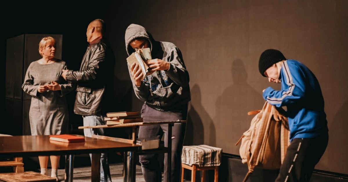 Сцена театрального спектакля с четырьмя актёрами на сцене.