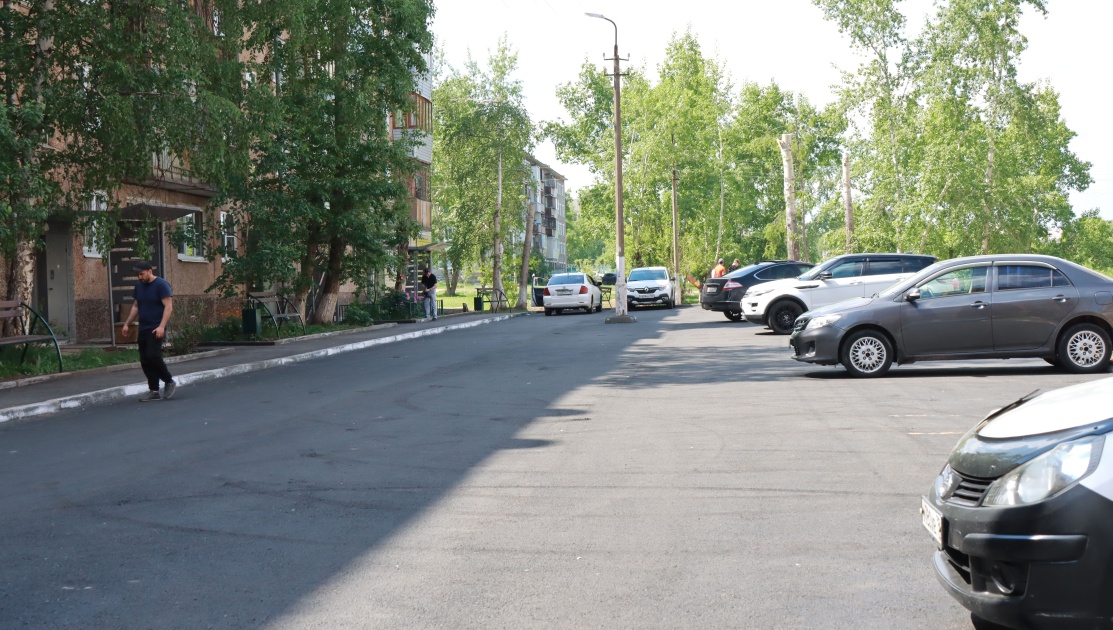 Асфальтированная парковка перед жилым домом.