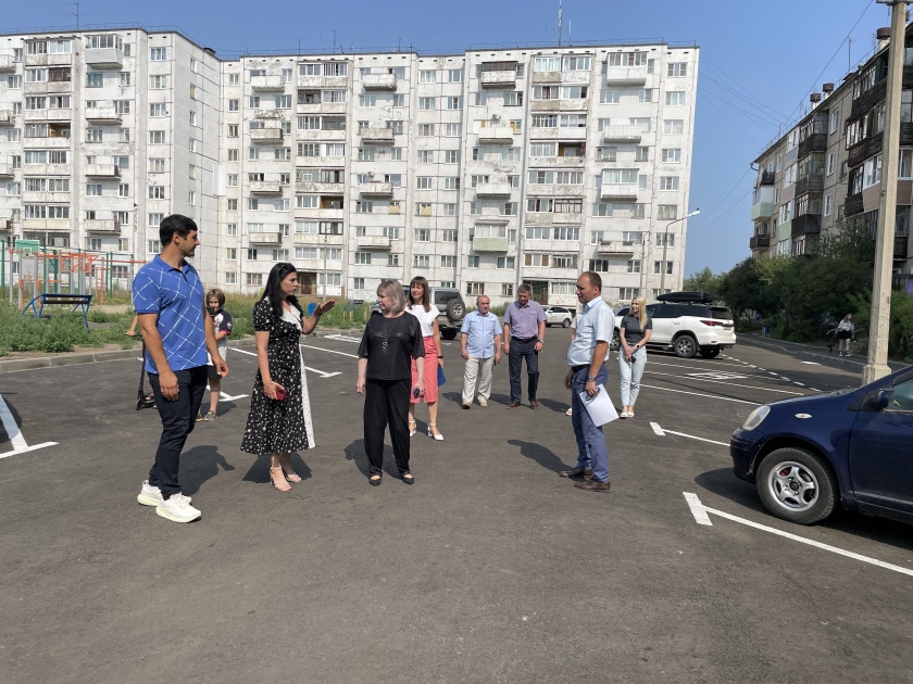 Люди обсуждают проект во дворе жилого дома.