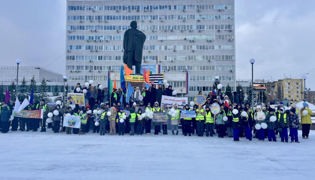 Демонстрация людей с плакатами и шарами на площади.