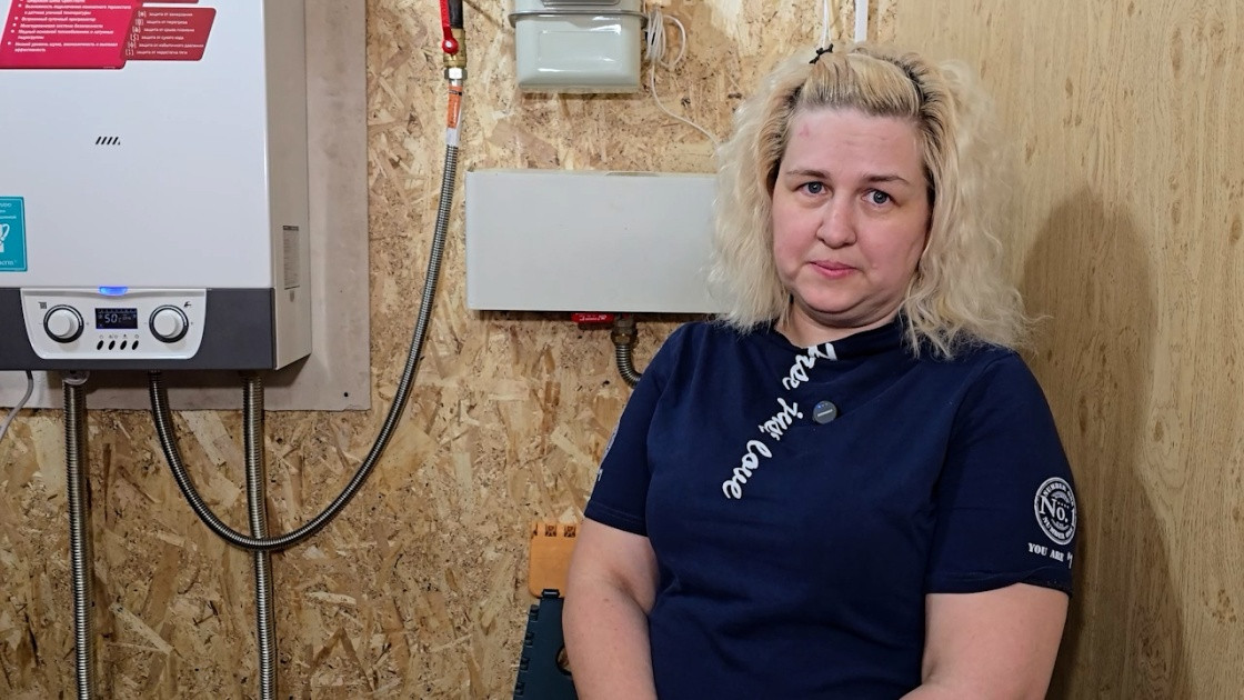 Женщина рядом с газовым котлом в помещении