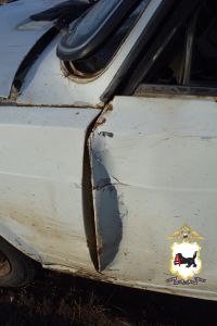 Поврежденная дверь белого автомобиля с ржавчиной