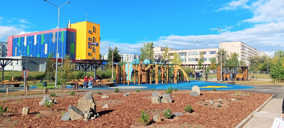 Детская площадка рядом с красочным зданием.