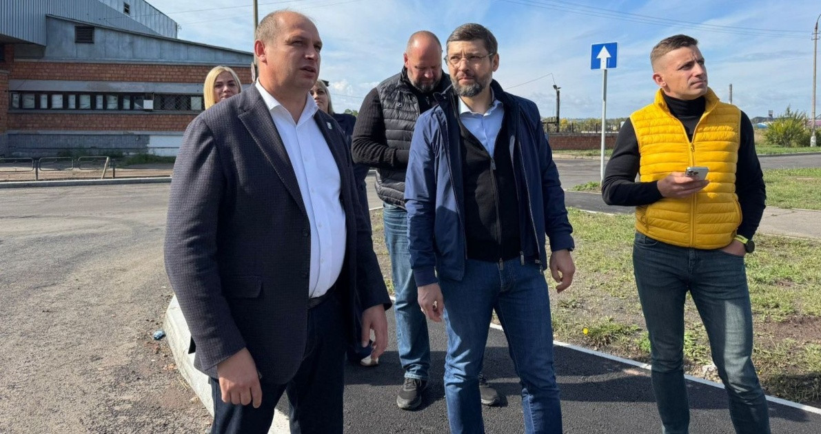 Группа людей обсуждает строительство на улице.