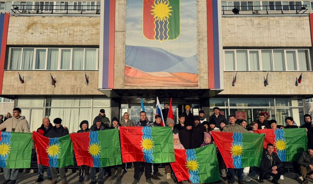 Люди с флагами на улице перед зданием