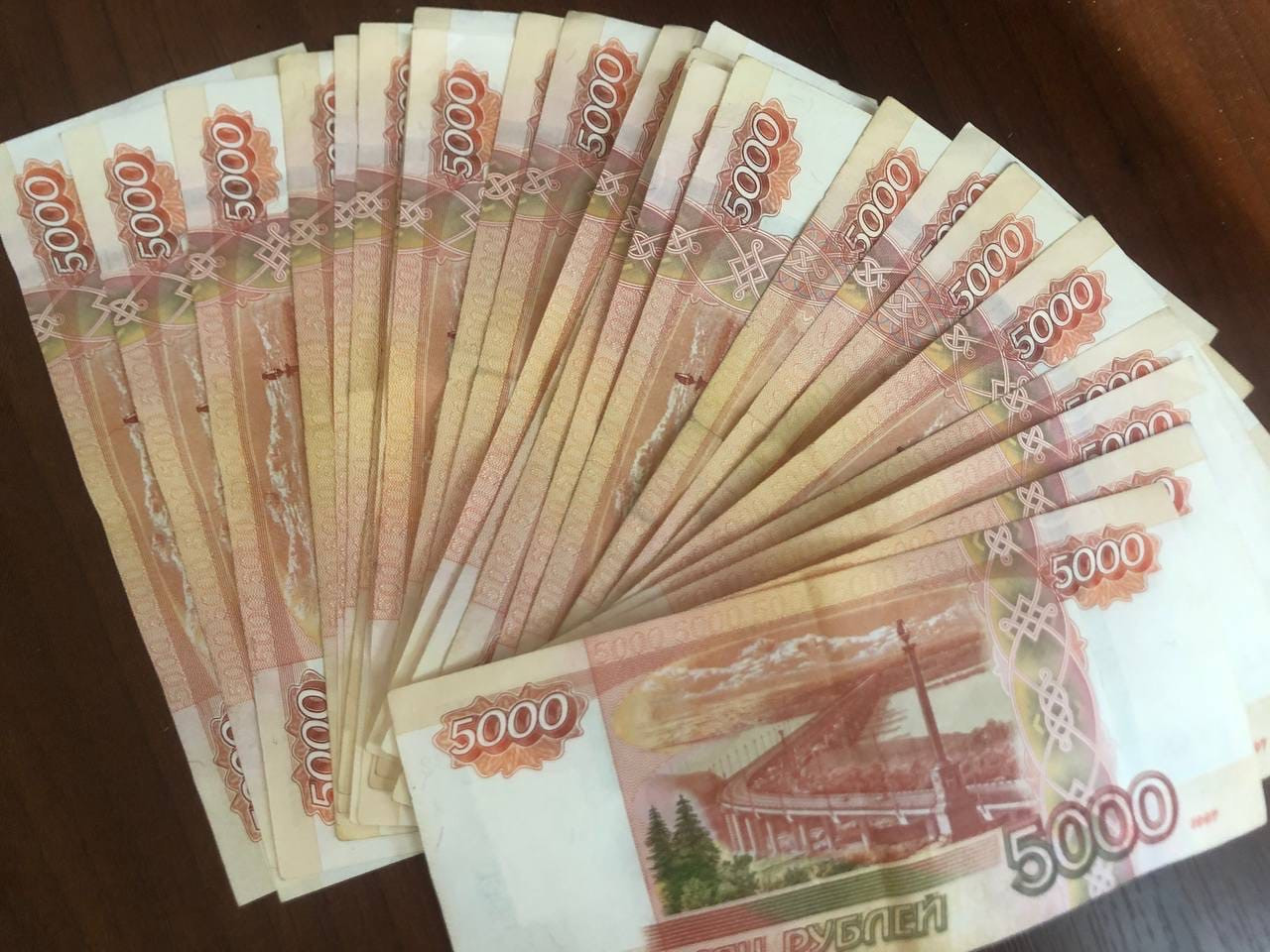 Купюры номиналом 5000 рублей на столе.
