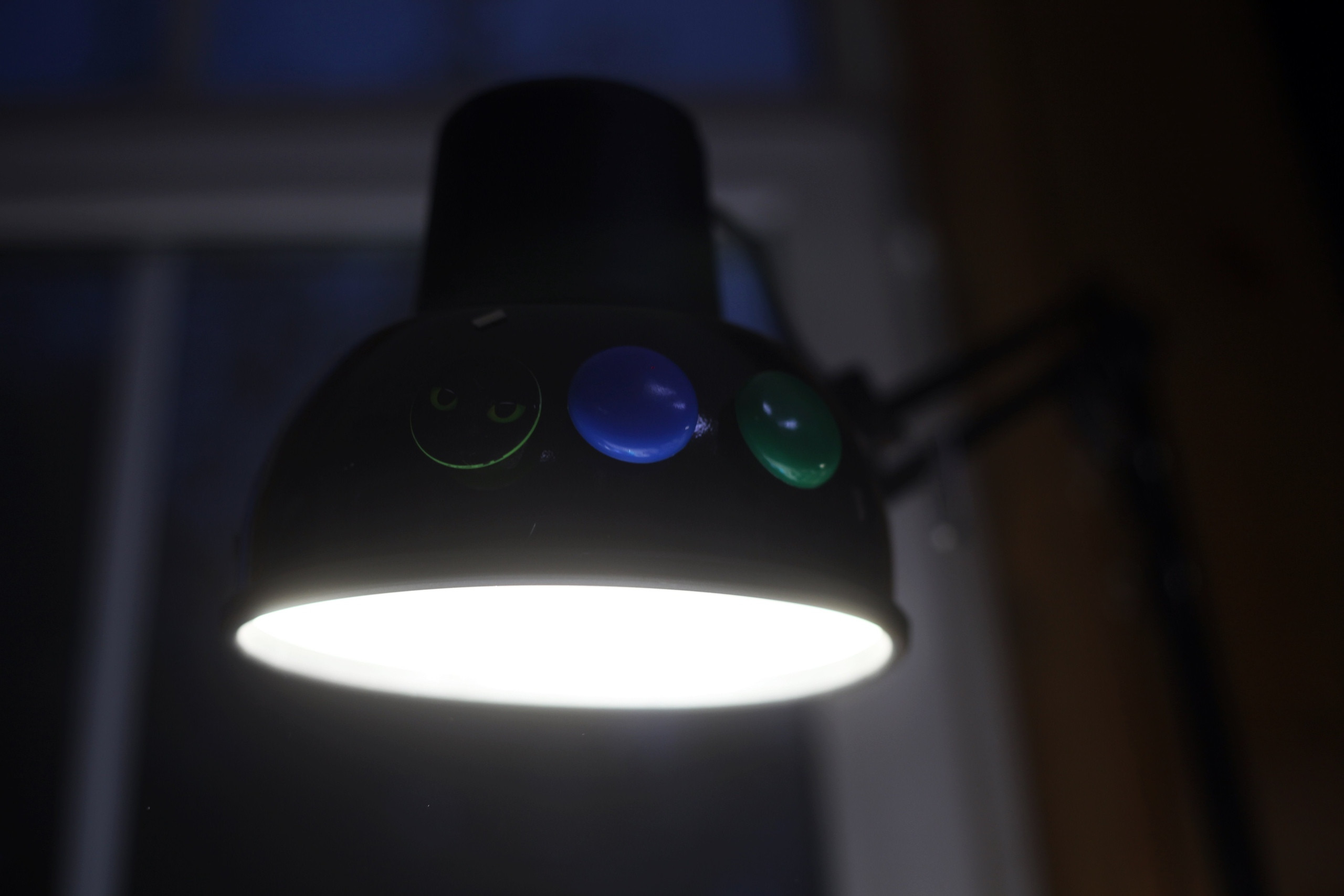 Настольная лампа с разноцветными кнопками освещает комнату