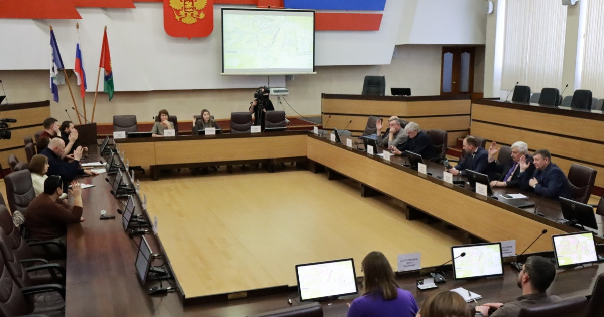 Заседание в конференц-зале с участниками и экранами.