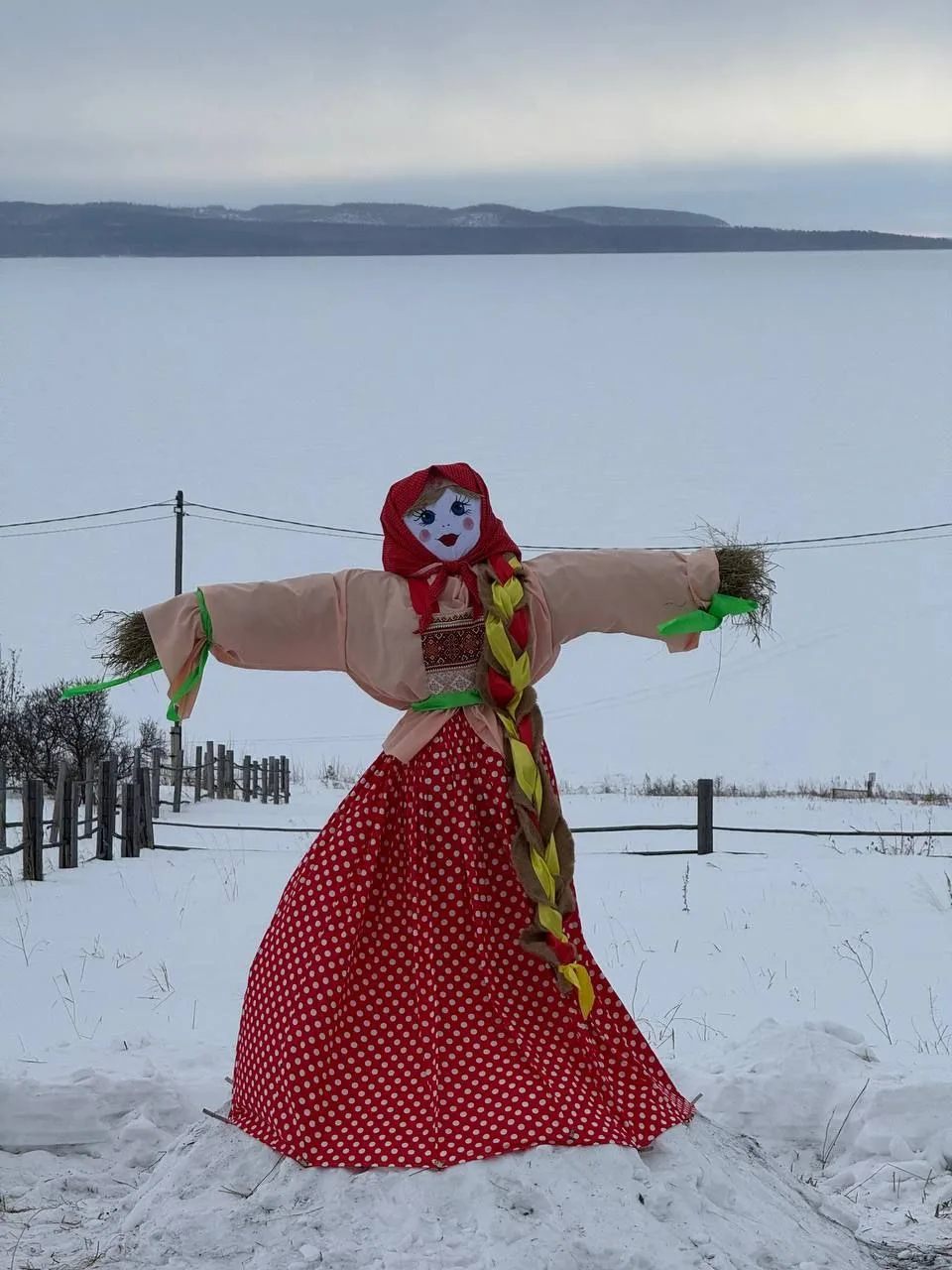 Чучело Масленицы на заснеженном фоне