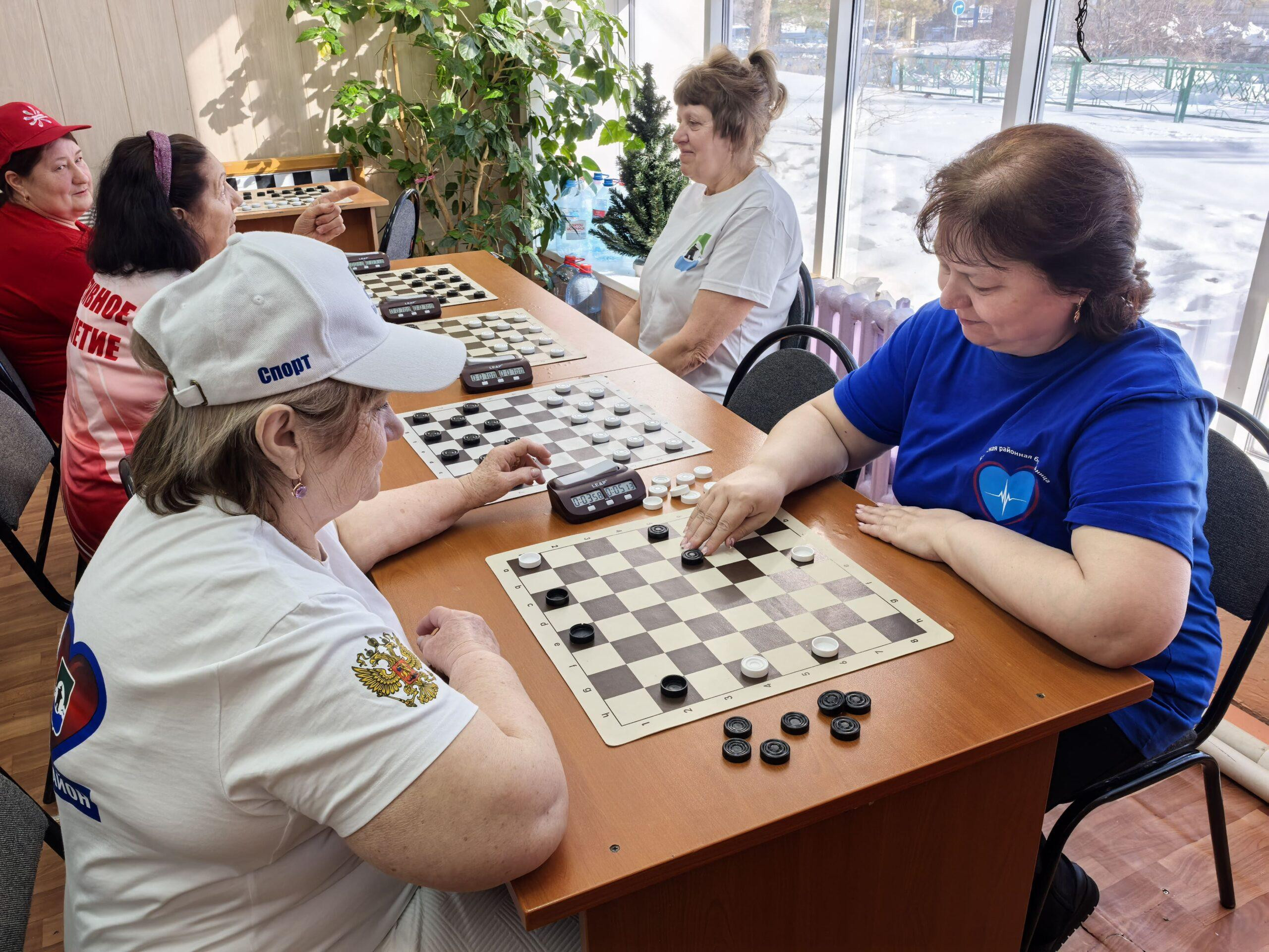 Женщины играют в шашки за столом
