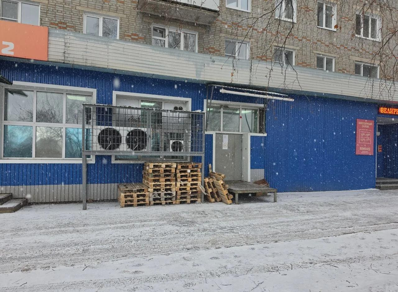 Синее здание с поддонами и кондиционерами зимой