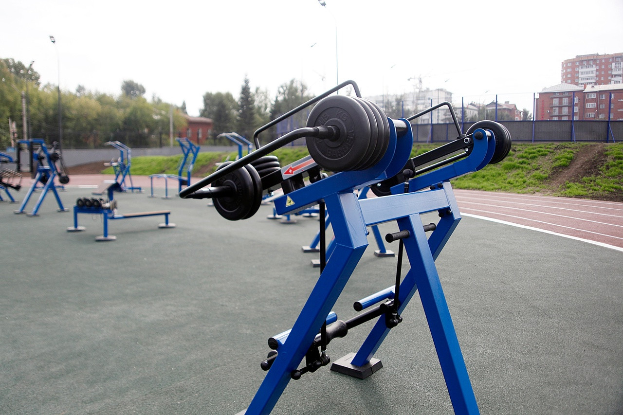Уличный тренажер с утяжелениями на спортивной площадке