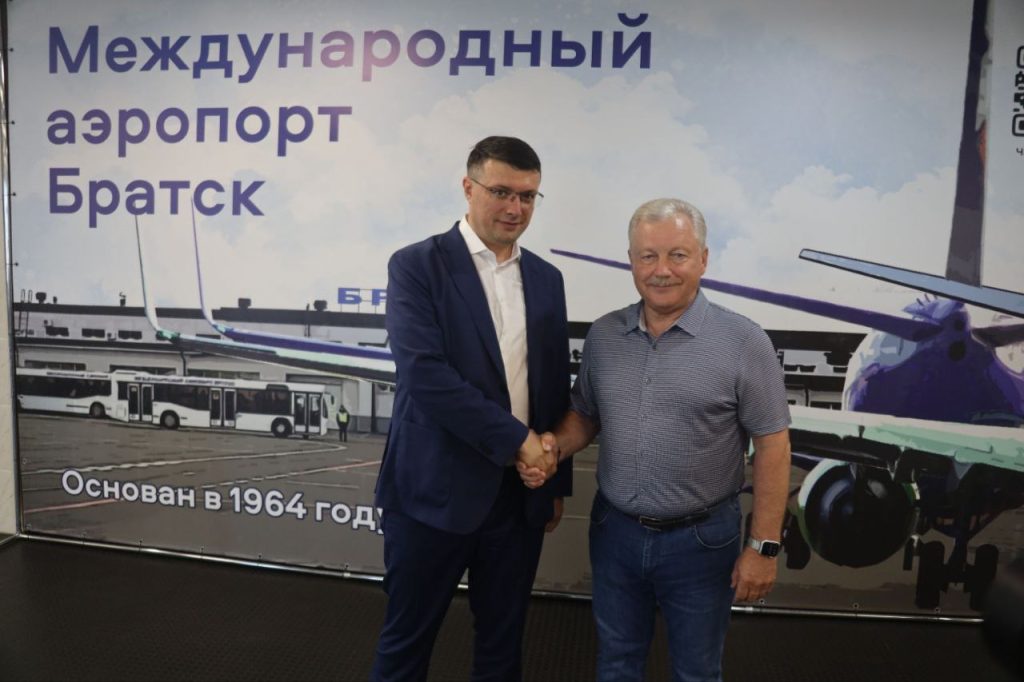Международный аэропорт Братск, два человека жмут руки.