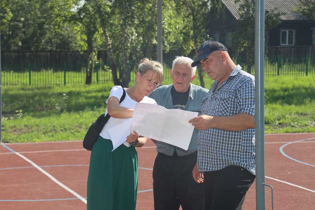 Люди обсуждают план на спортивной площадке.