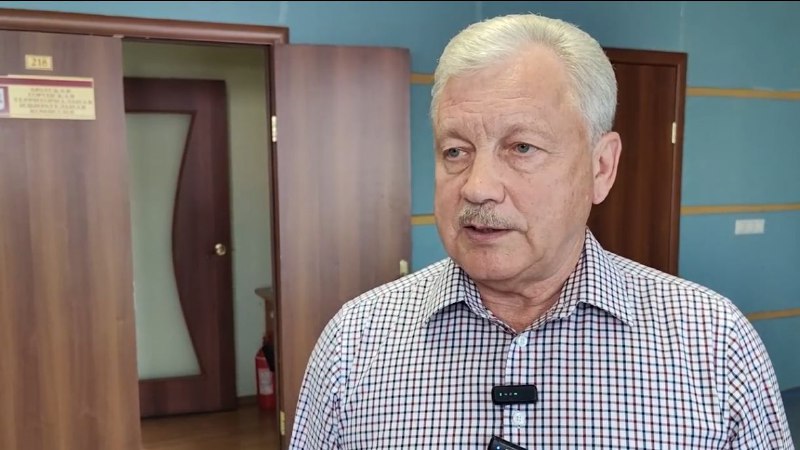 Мужчина в клетчатой рубашке в офисе.