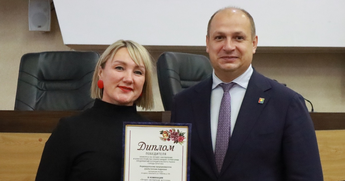Люди с дипломом на церемонии награждения.